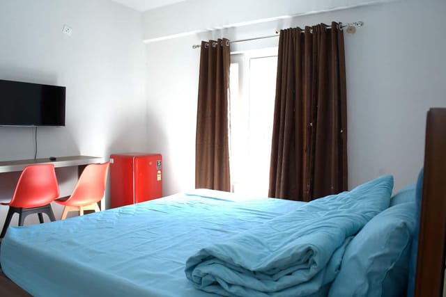Cozy hotel room with desk and natural light, perfect for informal gatherings and meetings.