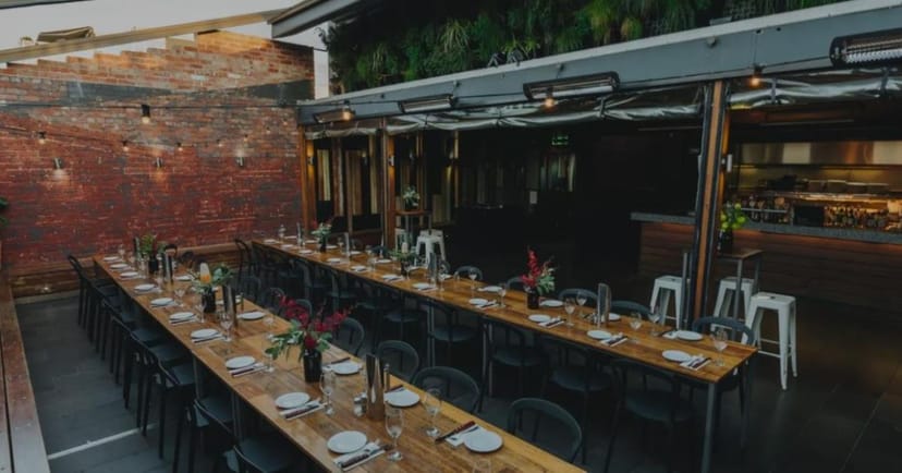 Rooftop Bar at Arcadia Hotel: long wooden table for corporate events and gatherings.