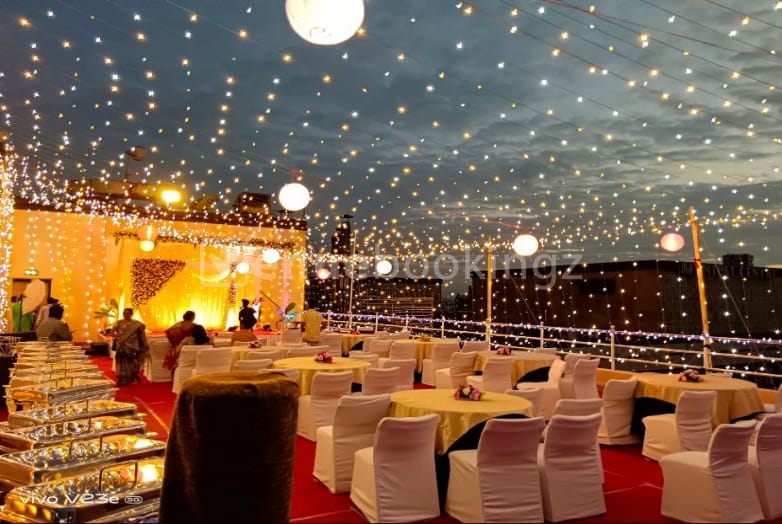 Elegant rooftop banquet hall adorned with fairy lights, perfect for weddings and parties.