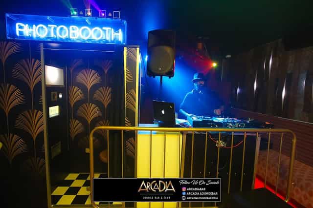 Vibrant Middle Bar with retro photobooth and DJ station for lively events.