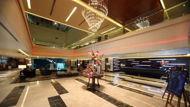 Gokulam Grand Hotel lobby with a striking chandelier, perfect for events and meetings.