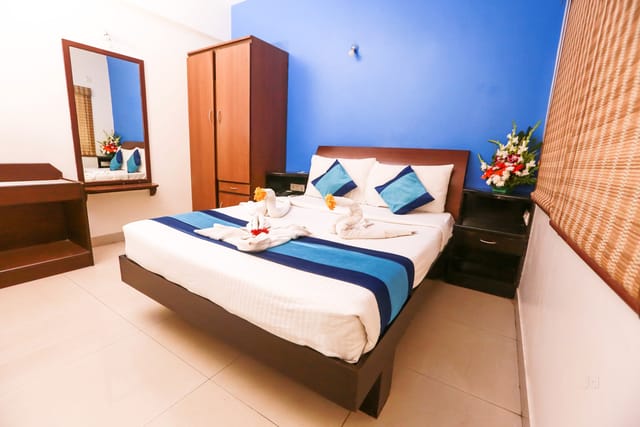 "Stylish guestroom in Green Path Eco Hotel with vibrant blue accent wall for events."