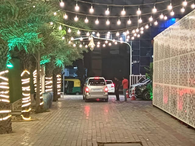 Elegant wedding reception hall entrance with string lights and lush greenery ambiance.
