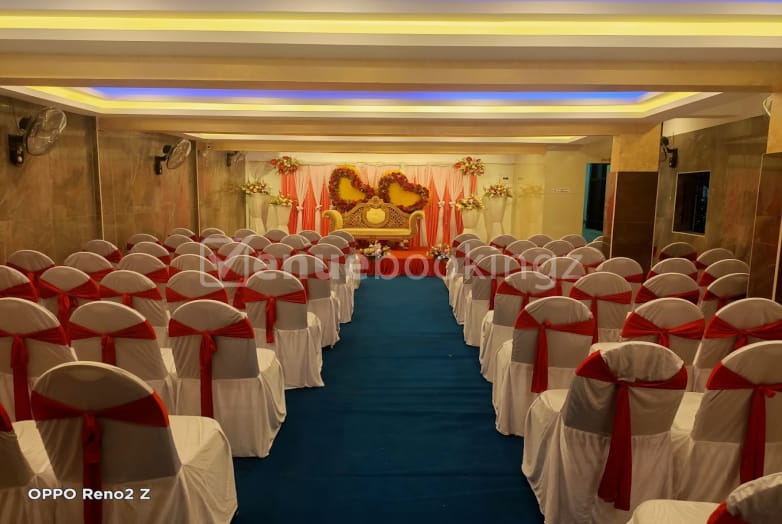 Elegant wedding reception hall with red-sashed chairs and floral decor at Thee Crystal Palace.