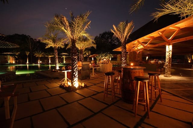 Luxurious outdoor event space at Mango Mist Resorts with palm trees, ideal for gatherings.