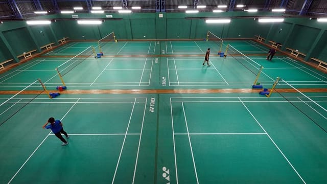 Spacious badminton court at Cospolitan Club, perfect for tournaments and team-building events.