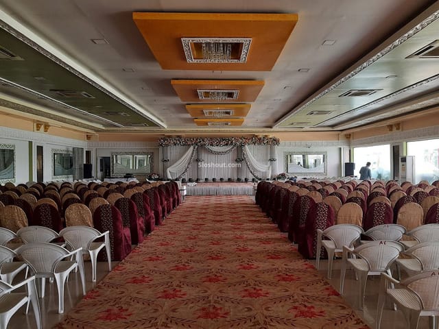 Spacious banquet hall with elegant chairs, perfect for weddings and conferences.
