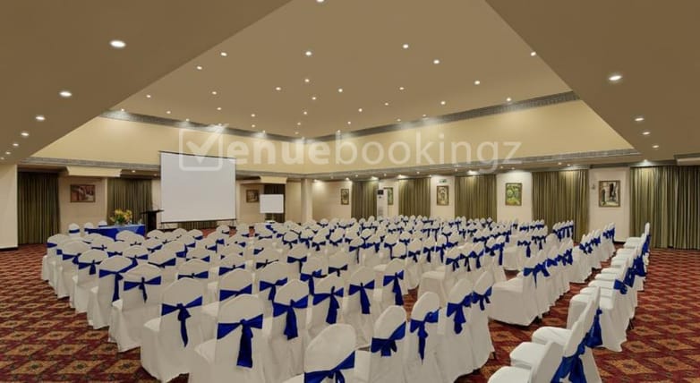 Banquet Hall at Golden Palms Hotel: conference setup with blue-sashed chairs for events.