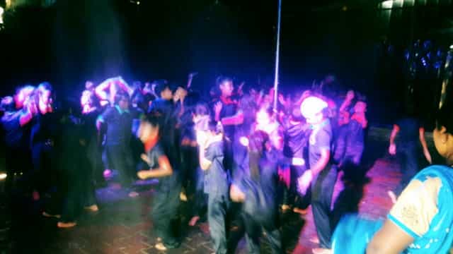 Vibrant event at Green Leaf Resort with lively dancing and dynamic lighting.