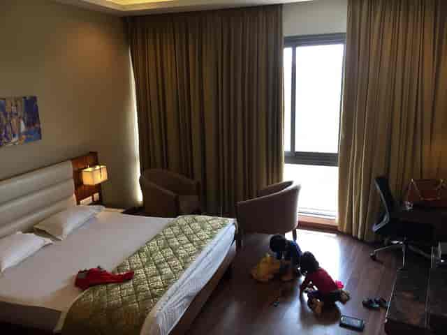 Spacious Bangalore Golf Club hotel room with modern decor for family-friendly events.