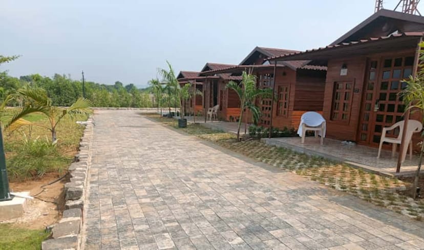 Serene garden area at Nirvana Resort with wooden structures for corporate events.