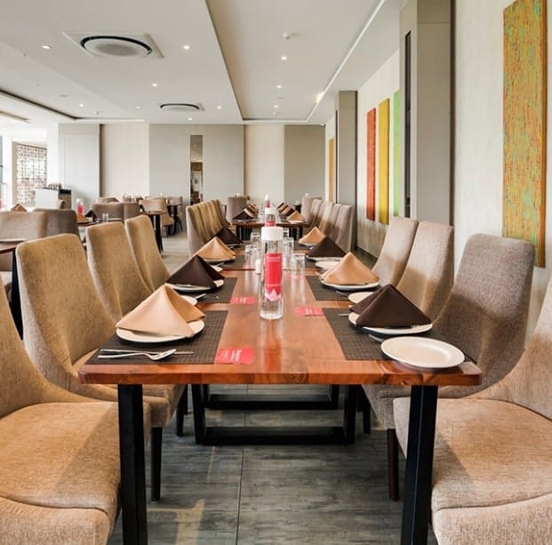 Elegant dining setup at B 64, Ramada Bengaluru for professional events and meetings.