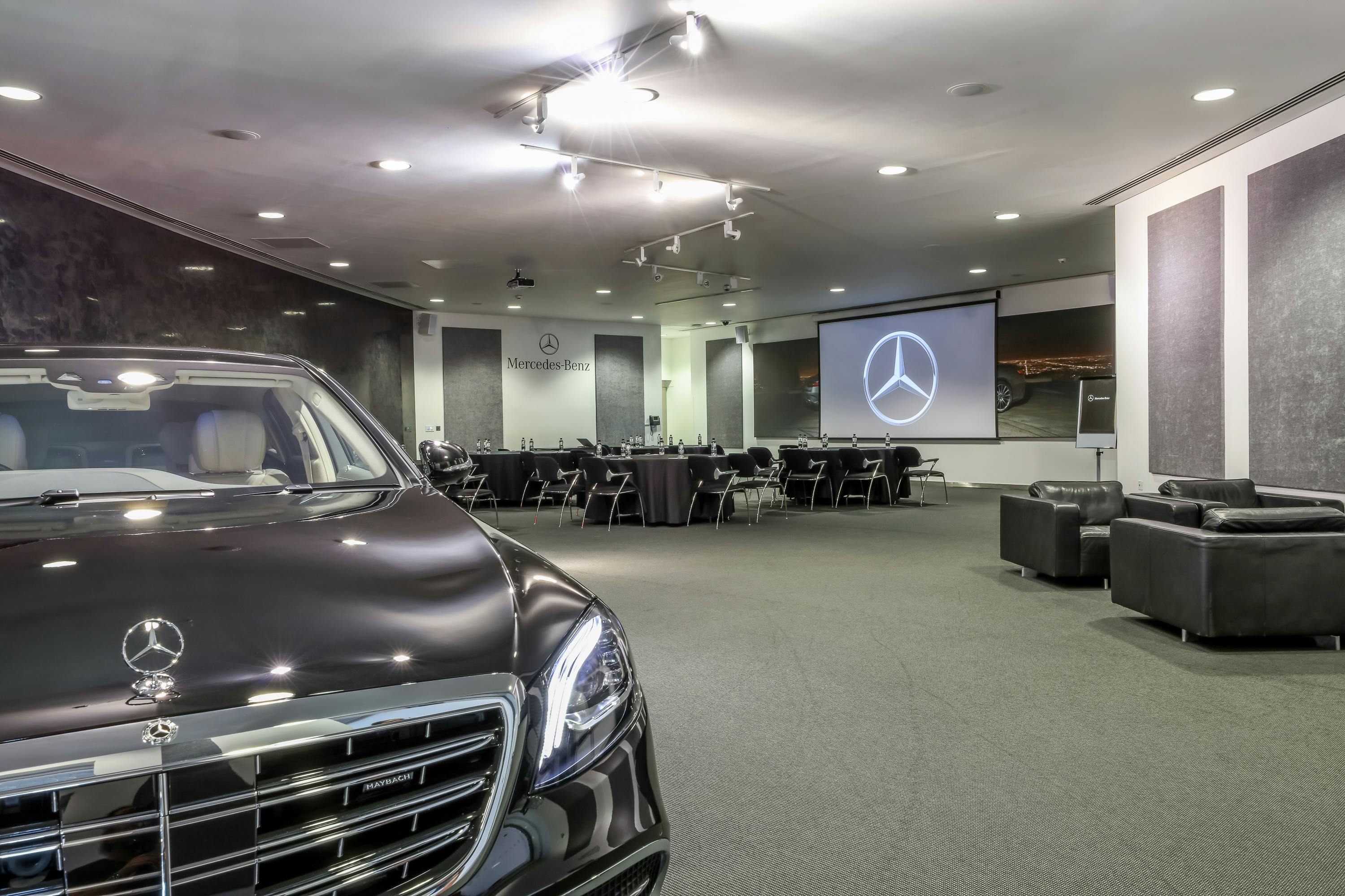 S-Class Suite at Mercedes-Benz World: modern event space with luxury vehicle, ideal for corporate events.