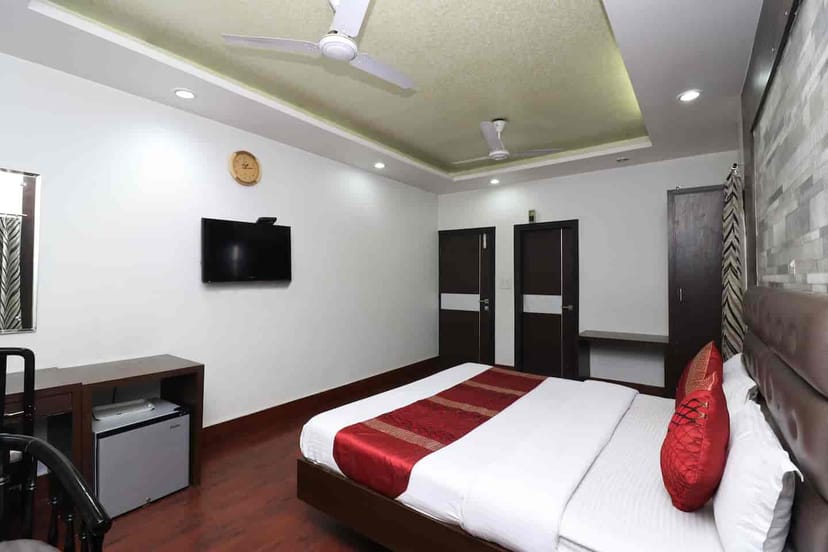 "Modern hotel room at OYO City Heart, ideal for business and events, features spacious design."