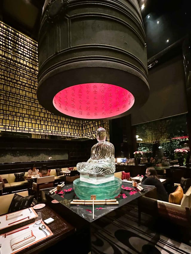 Sophisticated dining space with Buddha statue, perfect for upscale events and gatherings.