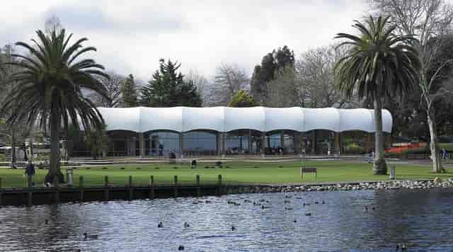 Contemporary waterfront cafe with lush palm trees, ideal for weddings and corporate events.