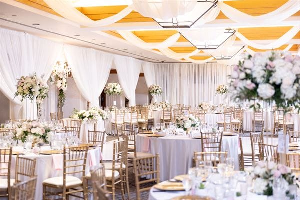 Elegant Oasis Ballroom setup for weddings with floral arrangements and fine dining.