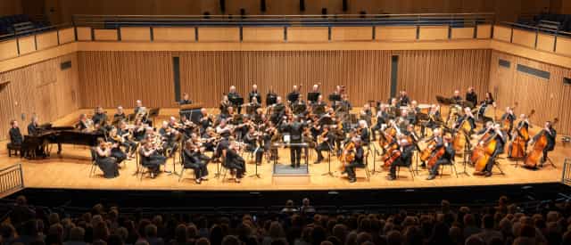 Orchestral performance in Saffron Hall highlighting conductor and vibrant live music events.
