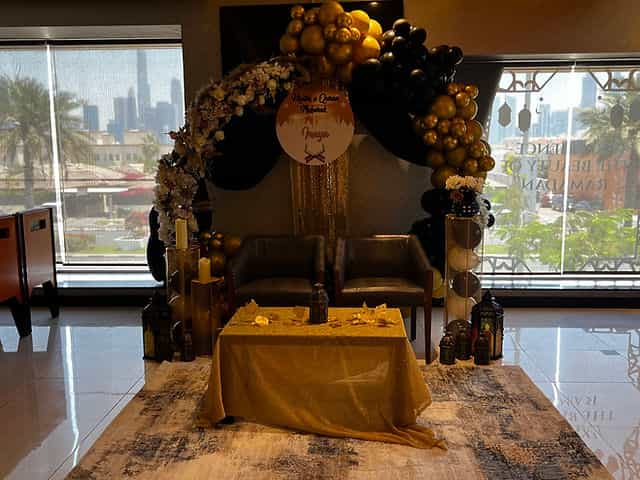 Elegant Mehndi & Dholki event at Karachi Grill with floral decor and gold-black theme.