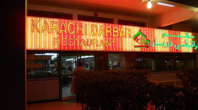 Karachi Darbari Restaurant's vibrant neon exterior, ideal for cultural events and dinners