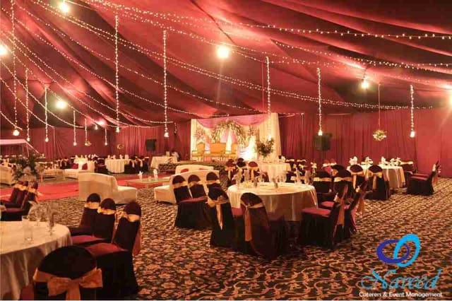 Elegant event space with burgundy drapery for weddings and formal celebrations.