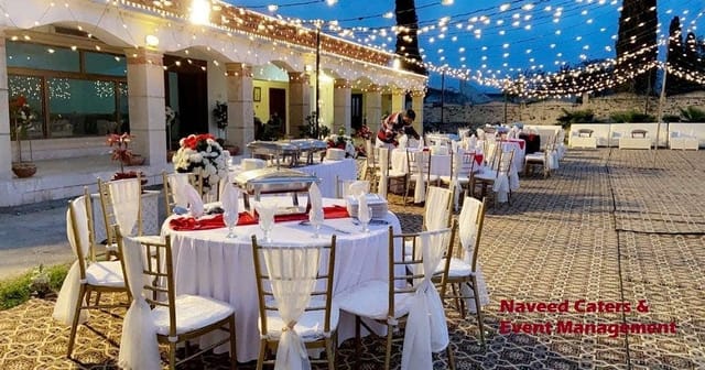 Outdoor wedding event space with string lights, elegant decor, and catering services.