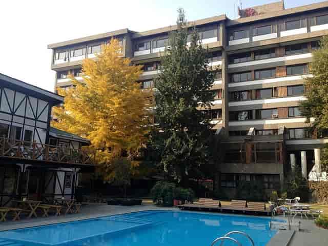 Outdoor cafe at Hotel Broadway with blue pool, ideal for meetings and events.
