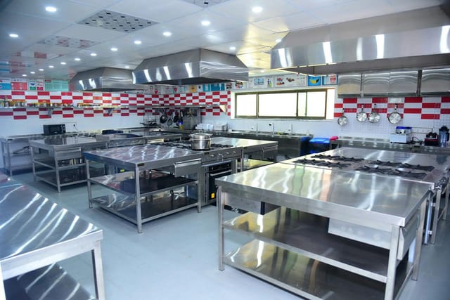 Modern commercial kitchen with stainless steel for culinary workshops and events.