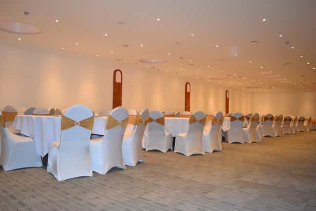 Elegant meeting space in Royal Mahal Atrium with white tables, ideal for corporate events.