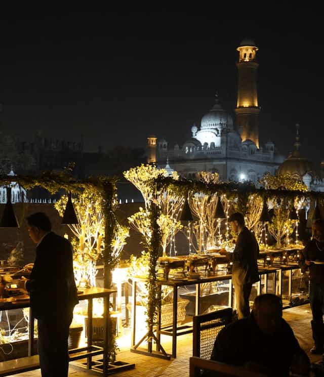 Elegant outdoor event space at Bastion Café Lahore Fort with ambient lighting and greenery.