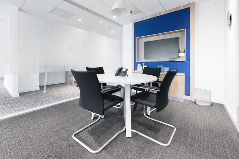 Modern Regus meeting room with round table, ideal for collaborative business events.