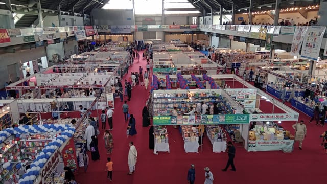 Lahore International Book Fair: bustling exhibition hall with vibrant vendor displays.