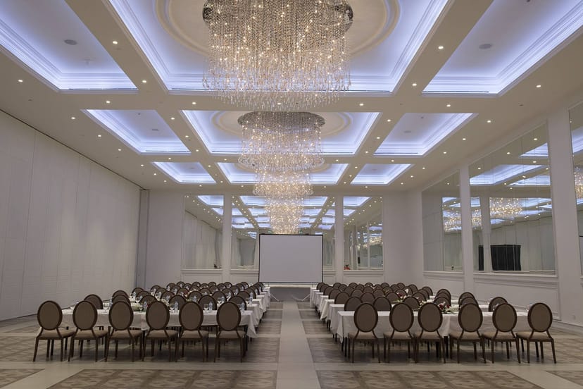 Elegant banquet hall with crystal chandeliers for corporate events and conferences.