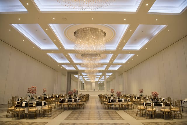 Elegant banquet hall with chandelier, perfect for weddings and corporate events.