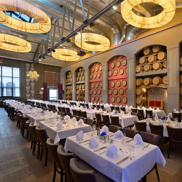 Chic banquet hall with wine barrels, ideal for corporate dinners and events.