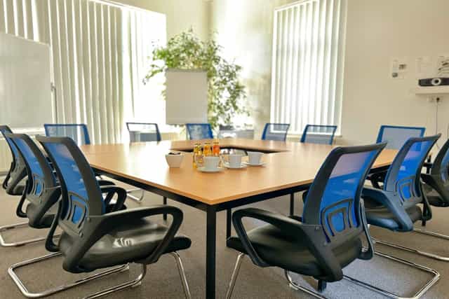 Modern meeting room with central table, ideal for collaborative sessions and events.