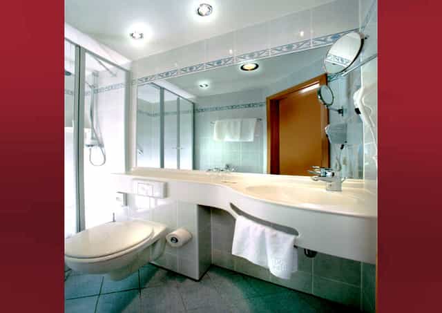 Modern restroom in Hotel Kurhaus Ochs with sleek fixtures for events and meetings.