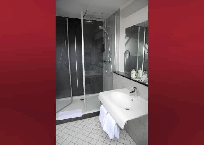 Modern hotel bathroom with glass shower at Hotel Kurhaus Ochs for events.