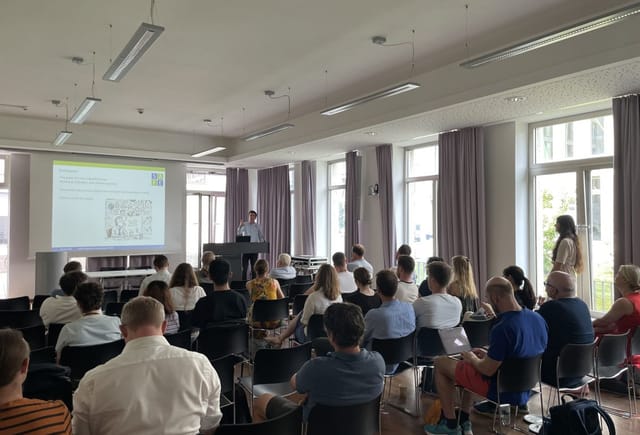 Goethe University Frankfurt seminar room with engaged audience at a professional presentation.