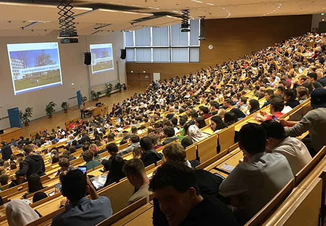 Auditorium at Goethe University for an academic conference with attendees and multimedia setup.