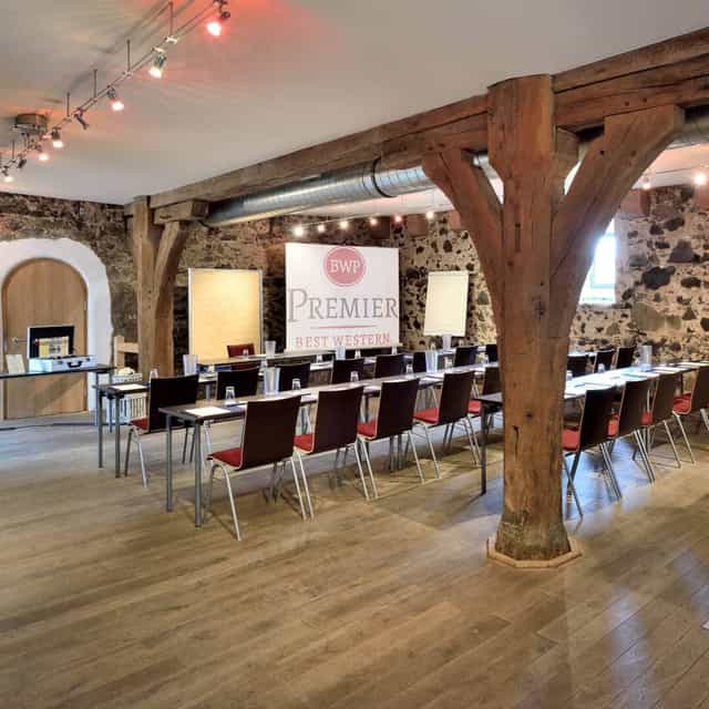 Meeting room with natural lighting and wooden beams for workshops at Villa Stokkum.