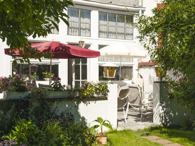 Charming outdoor garden venue with seating for receptions and networking events.
