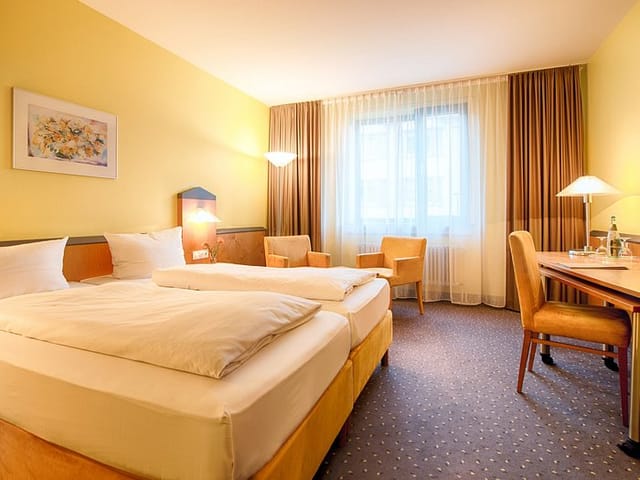 Luxurious hotel suite with twin beds in Plaza Hotel Frankfurt, perfect for events.