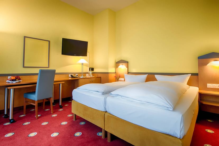Well-lit suite with two beds in Plaza Hotel Frankfurt, ideal for business events.