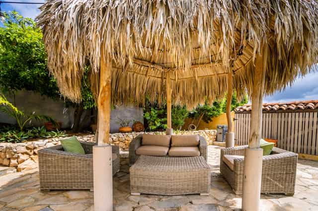 Inviting outdoor lounge at Villa Orange with thatched roof for casual events and networking.