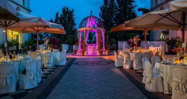 Outdoor wedding venue at Villa il Poggione with elegant tables and floral canopy.