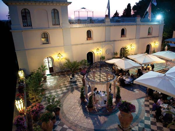 Elegant wedding venue with tiled courtyard & umbrellas at Villa il Poggione for outdoor events.