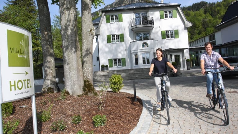 Cyclists approaching Hotel Villa Ludwig, ideal for retreats and team-building activities.