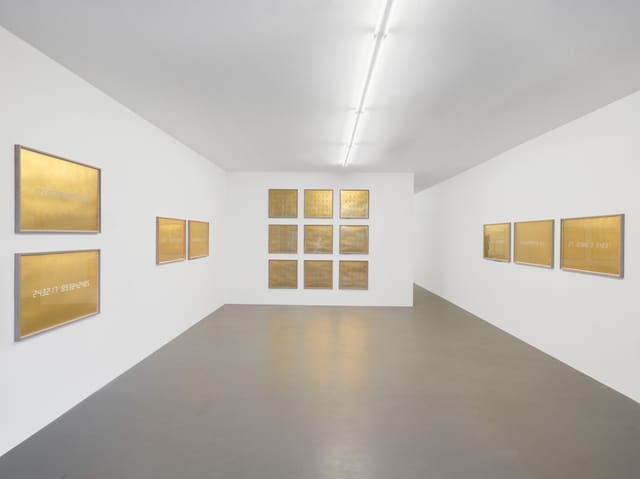 Minimalist gallery space with golden artwork, ideal for art receptions and corporate events.