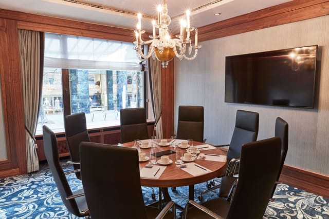 Grüner Salon meeting room with round table, chandelier, ideal for conferences and events.